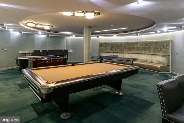 a room with furniture pool table and window