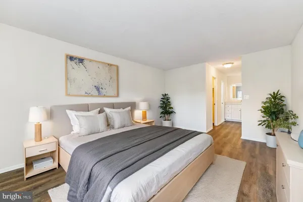 a bedroom with a large bed and a potted plant