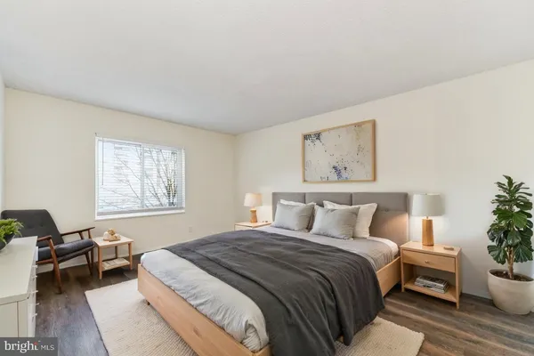 a bedroom with a large bed and a potted plant
