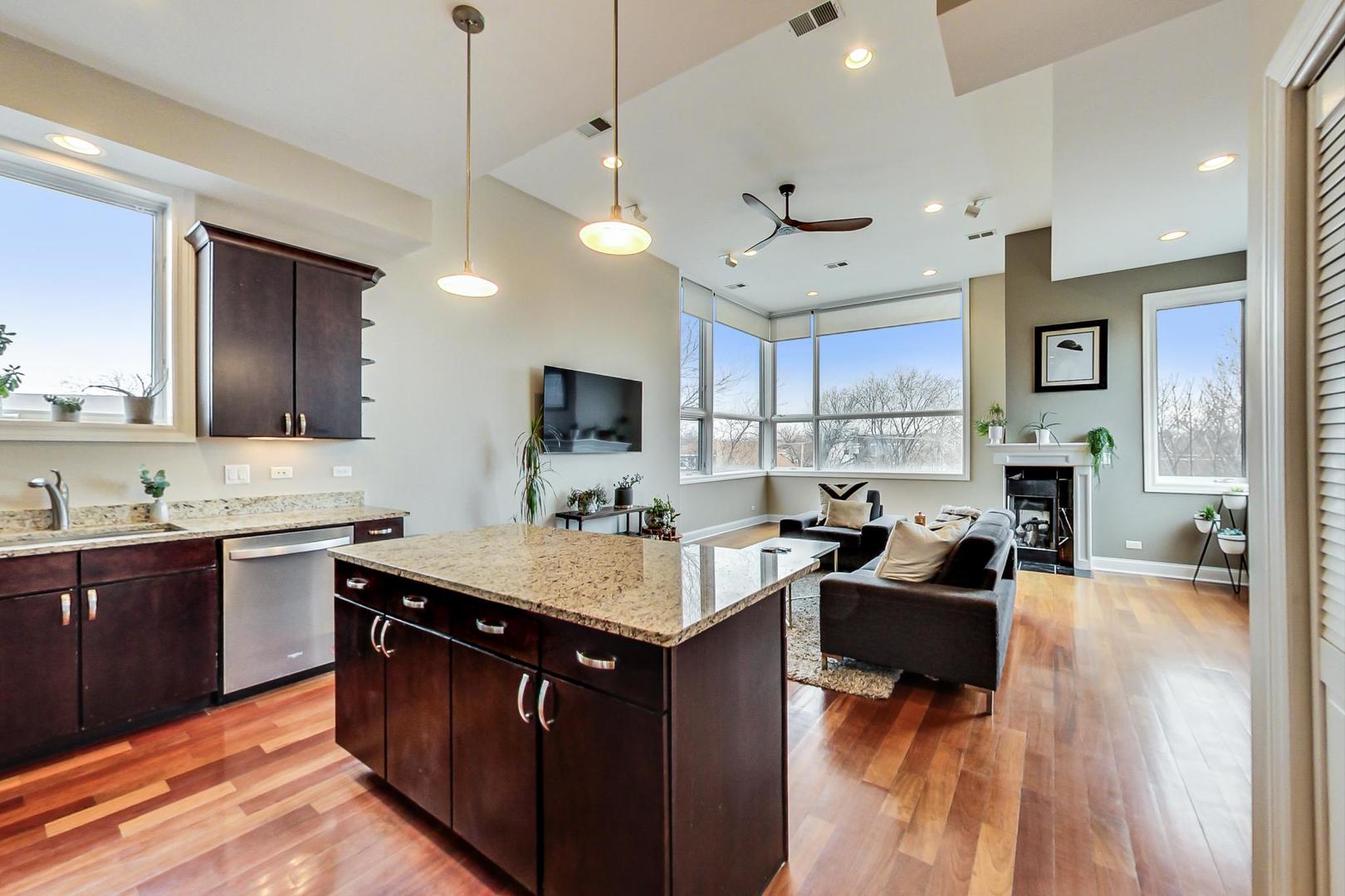 3605 South Leavitt Street, Unit 3 Chicago, IL 60609 - Photo 8 of 22 a kitchen with a stove a sink dishwasher a refrigerator and a dining table with wooden floor