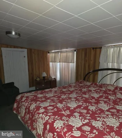 a bed sitting in a spacious bedroom next to a window