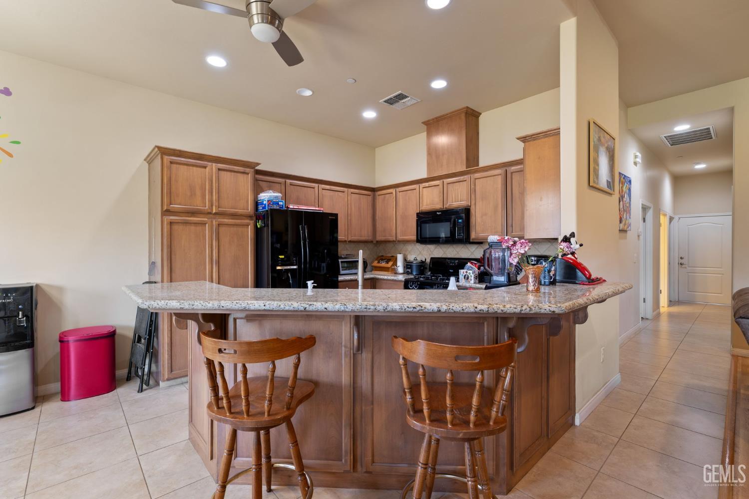 Undisclosed Address Bakersfield, CA 93314 - Photo 12 of 45 a kitchen with stainless steel appliances kitchen island granite countertop a sink and cabinets