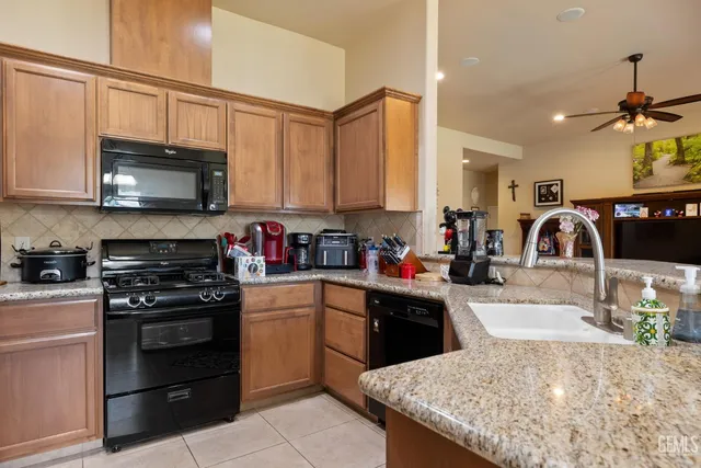 a kitchen with stainless steel appliances granite countertop a sink a stove and a microwave