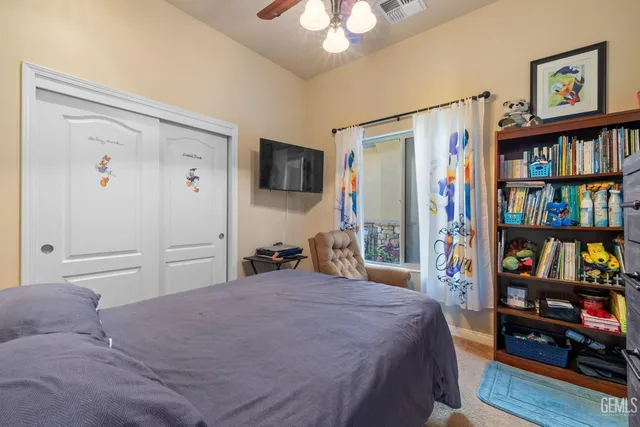 a bedroom with a bed a book shelf and a window