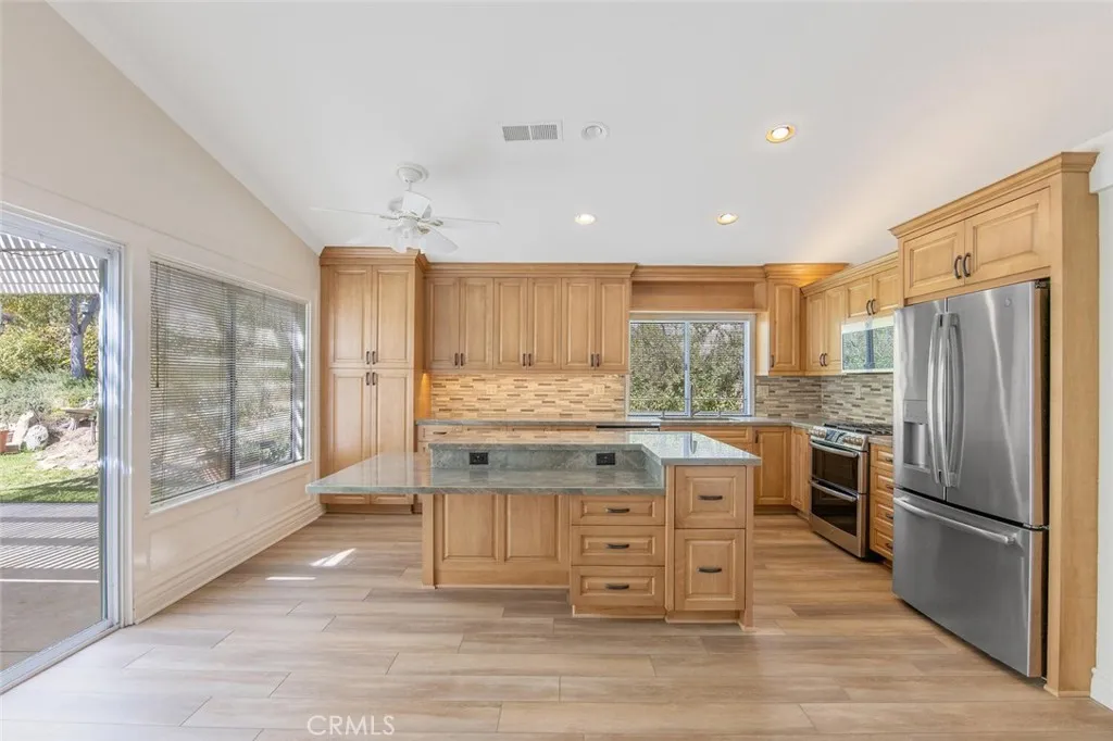 27619 Ron Ridge Drive Saugus, CA 91350 - Photo 10 of 37 a kitchen with stainless steel appliances granite countertop a stove refrigerator and cabinets