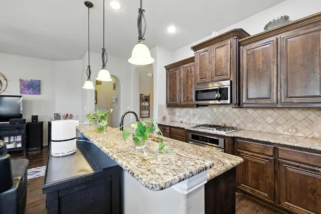a kitchen with a dining table stainless steel appliances and chandelier