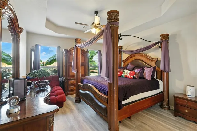 a bedroom with a bed a chandelier and a dresser