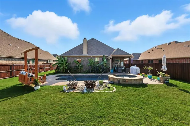 a view of a backyard with couches under an umbrella