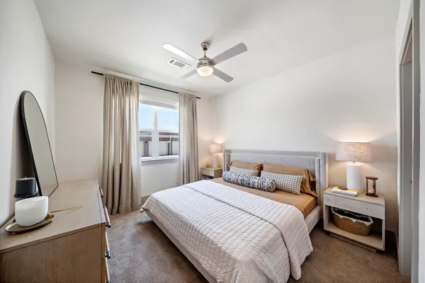 a bedroom with a bed and a flat tv screen on a dresser