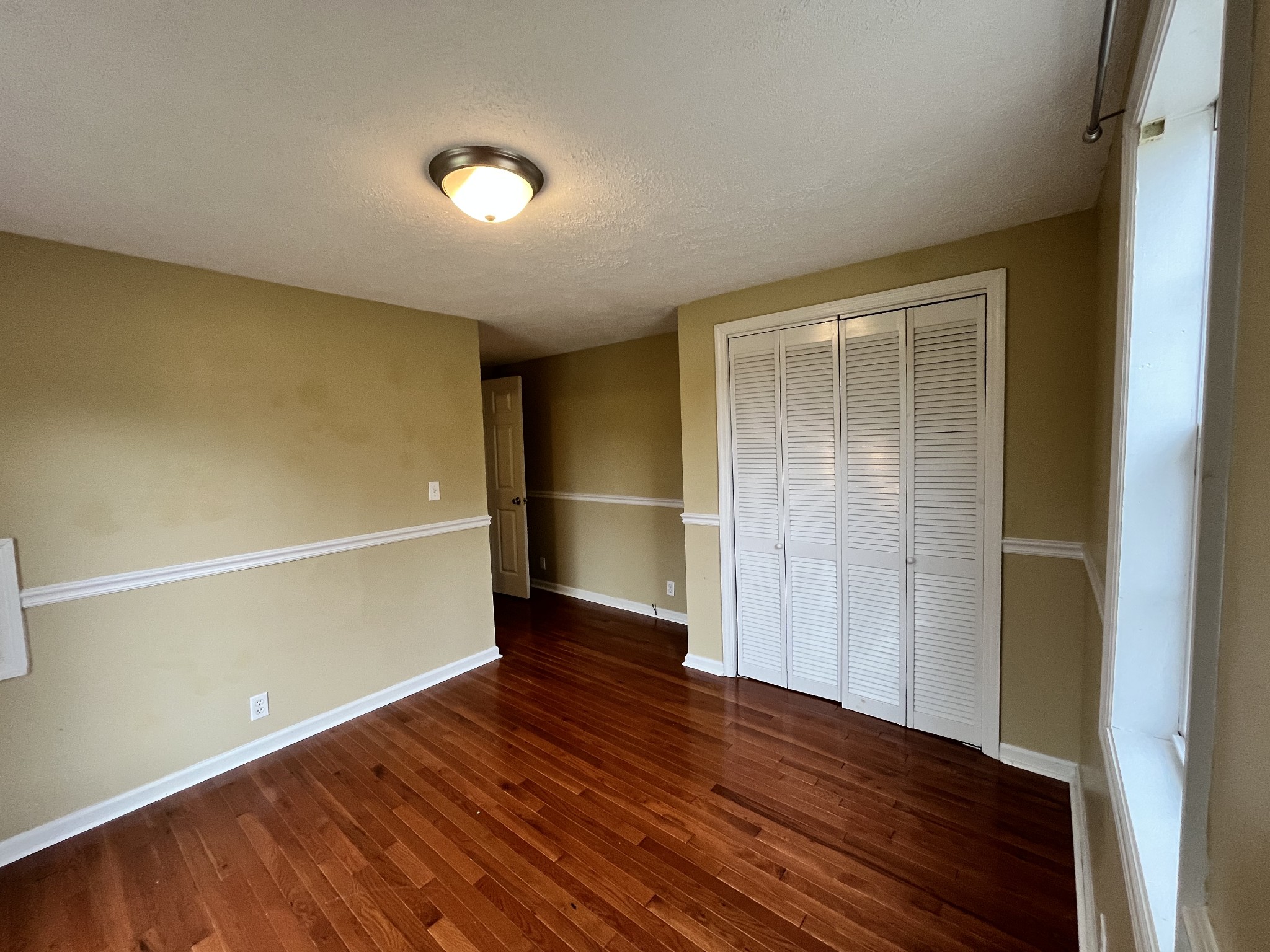 1763 Highway 166 Mount Pleasant, TN 38474 - Photo 26 of 40 a view of an empty room with wooden floor and a window