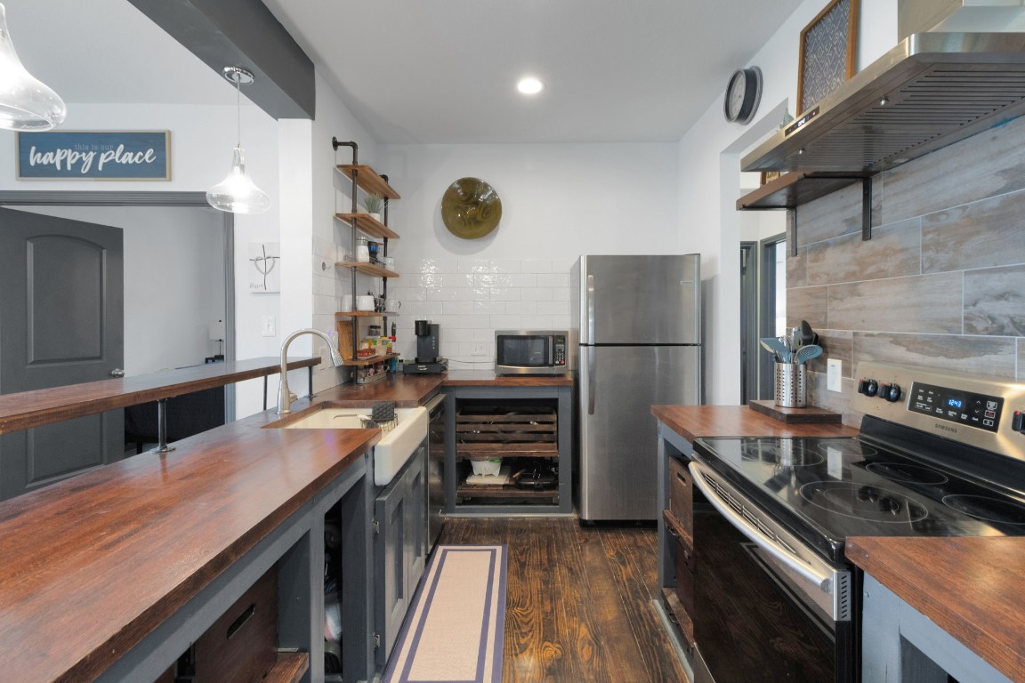 171 Kings Way Coldspring, TX 77331 - Photo 8 of 50 a kitchen with kitchen island a counter space a stove and a refrigerator