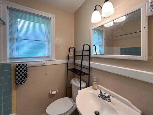 a bathroom with a sink mirror vanity and toilet