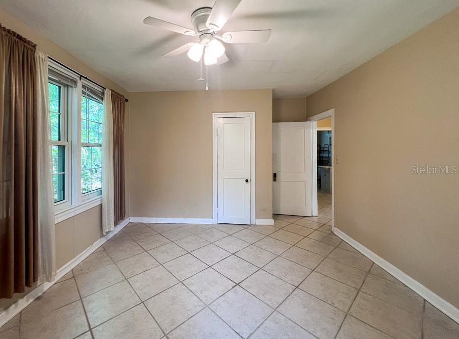 1033 Northwest 22nd Avenue Gainesville, FL 32609 - Photo 14 of 25 an empty room with chandelier fan and windows