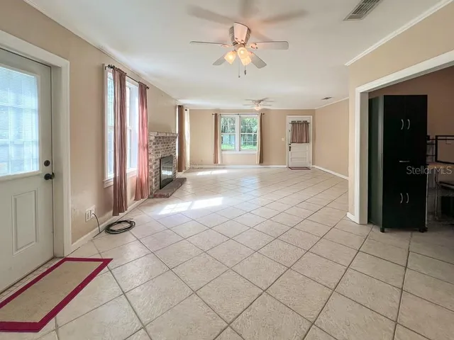 a view of a livingroom with a chandelier fan and windows