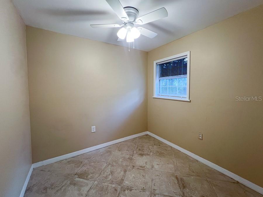 1033 Northwest 22nd Avenue Gainesville, FL 32609 - Photo 19 of 25 an empty room with a window and a fan