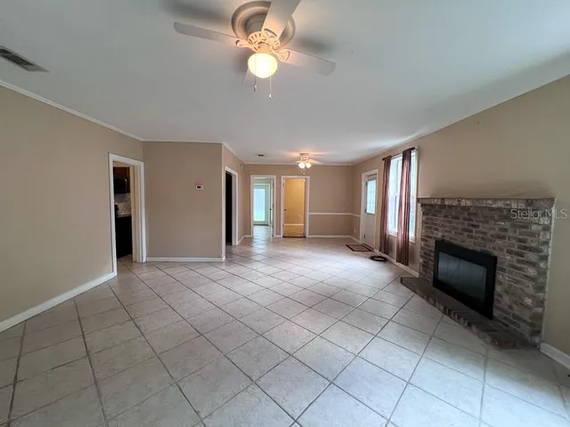 a view of an empty room with a fireplace and a window