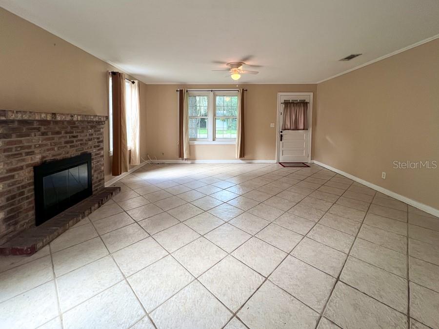 1033 Northwest 22nd Avenue Gainesville, FL 32609 - Photo 6 of 25 a view of an empty room with a fireplace and a window
