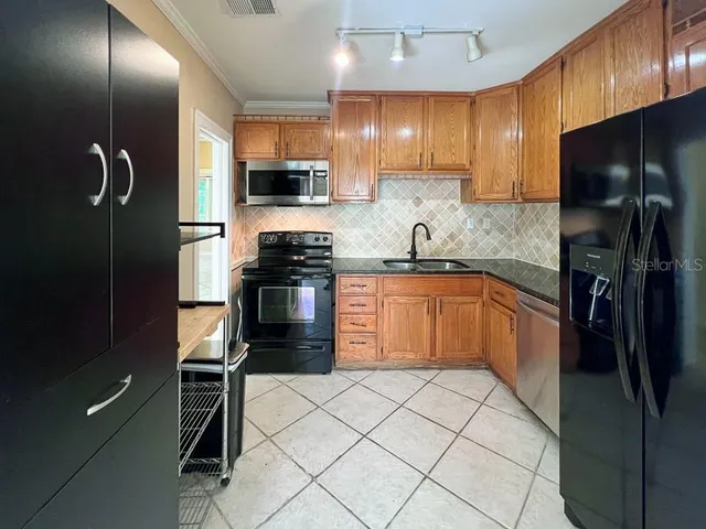 a kitchen with stainless steel appliances granite countertop a refrigerator and a sink