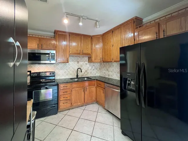 a kitchen with stainless steel appliances granite countertop a refrigerator and a sink
