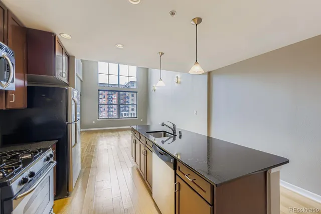 a kitchen that has a sink a stove and a wooden floor