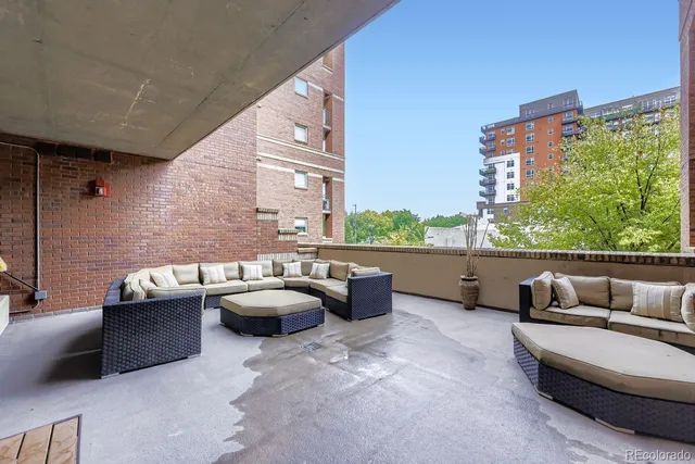 a roof deck with couches and potted plants