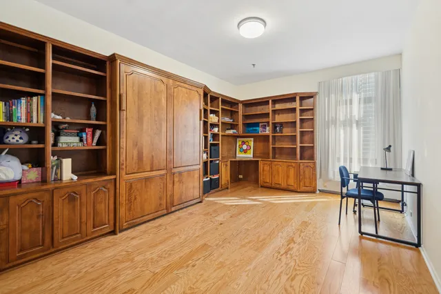 a view of an empty room with window and cabinet