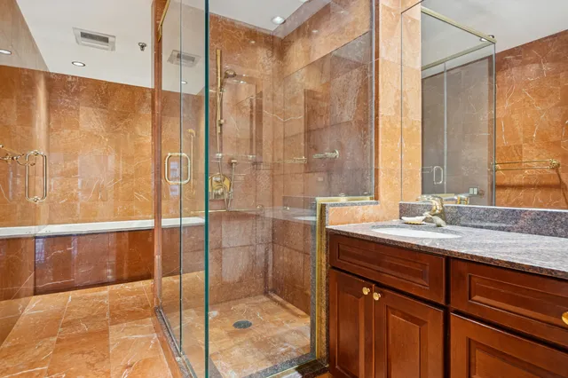 a bathroom with a granite countertop sink mirror and shower