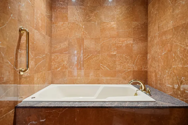 a bathroom with a granite countertop bathtub and shower