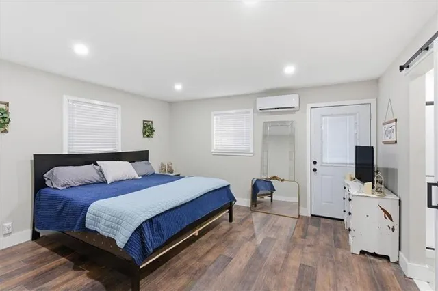 a bedroom with a large bed and a flat tv screen on dresser