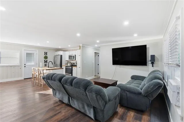 a bedroom with a large bed and a flat tv screen on dresser