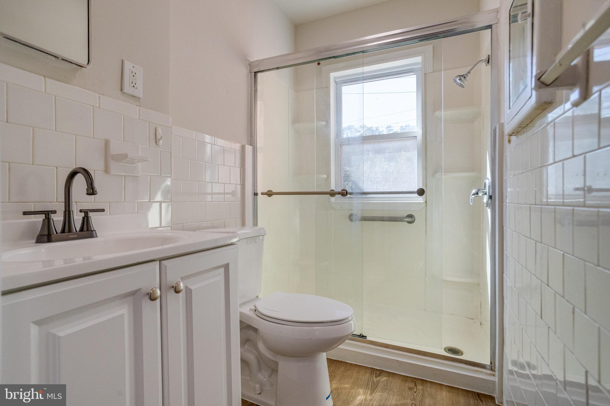 5878 Belair Road Baltimore, MD 21206 - Photo 22 of 41 a bathroom with a sink a toilet and shower