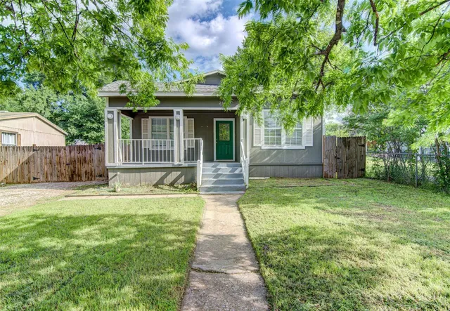 a view of a house with backyard and a tree