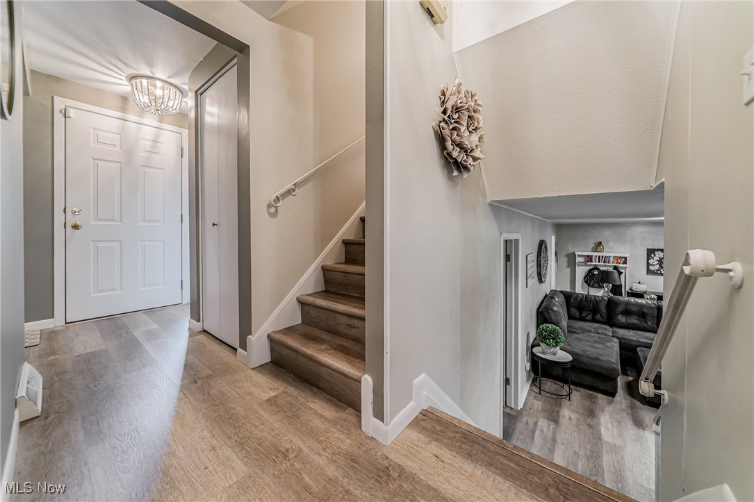 595 Moorfield Road Fairlawn, OH 44313 - Photo 19 of 50 Stairs featuring wood finished floors and a chandelier