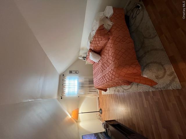 82 Westcott Street Inwood, NY 11096 - Photo 17 of 24 a bed sitting in a room next to a lamp