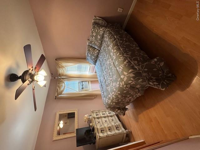 82 Westcott Street Inwood, NY 11096 - Photo 10 of 24 a spacious bedroom with a bed and a chandelier