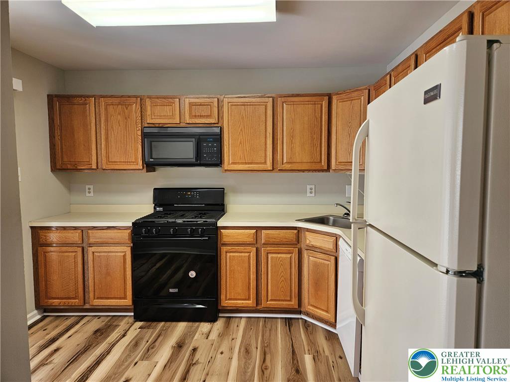 1876 Mansfield Street Hellertown, PA 18055 - Photo 8 of 19 a kitchen with a refrigerator a stove top oven a sink and dishwasher with wooden floor
