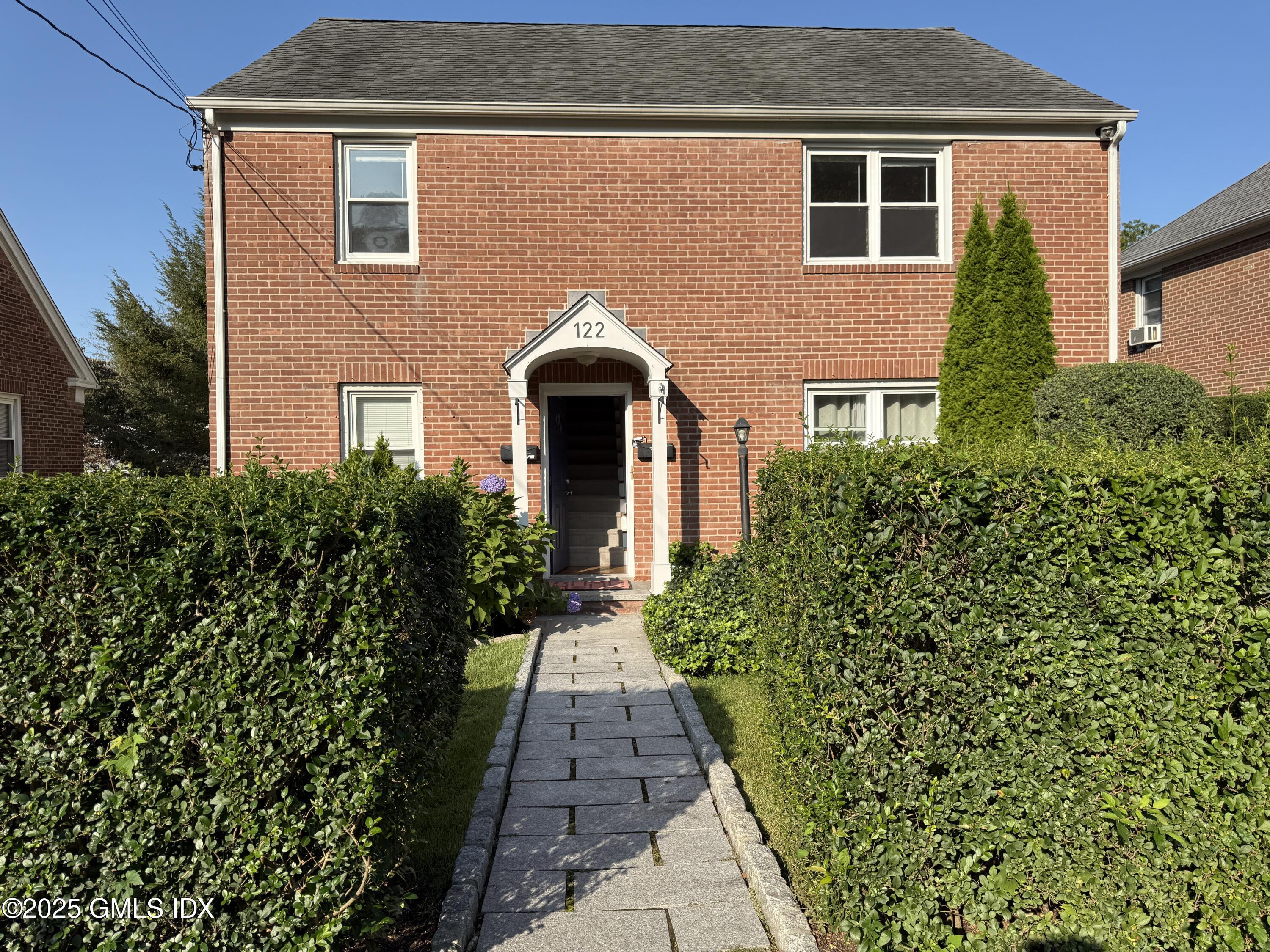 122 Pemberwick Road, Unit 2 Greenwich, CT 06831 - Photo 1 of 17 a front view of a house with a yard