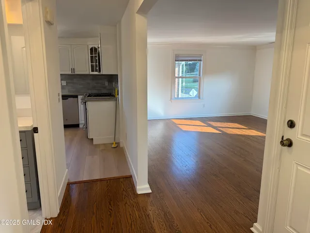an empty room with wooden floor and a window