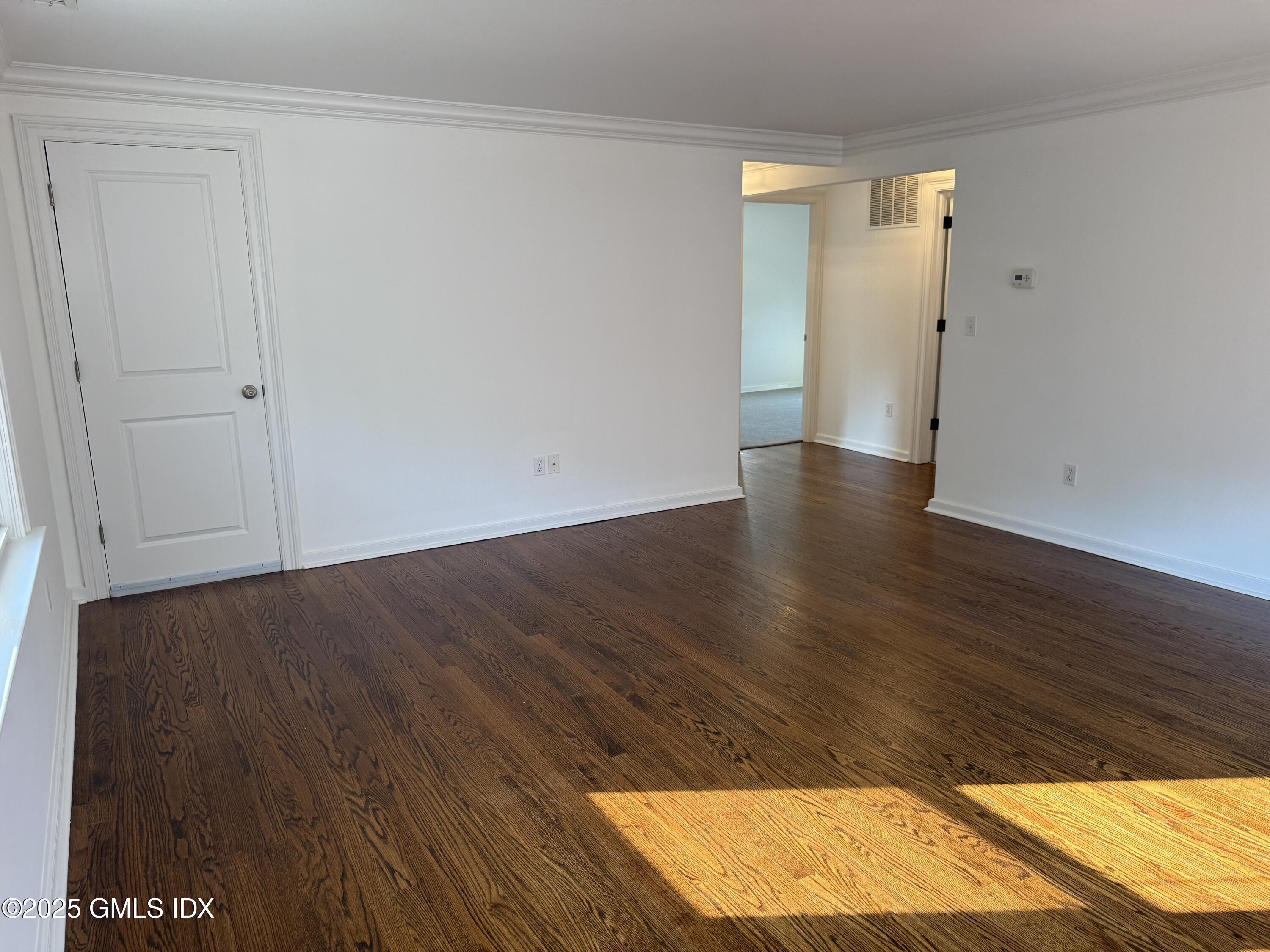 122 Pemberwick Road, Unit 2 Greenwich, CT 06831 - Photo 13 of 17 an empty room with wooden floor and a window