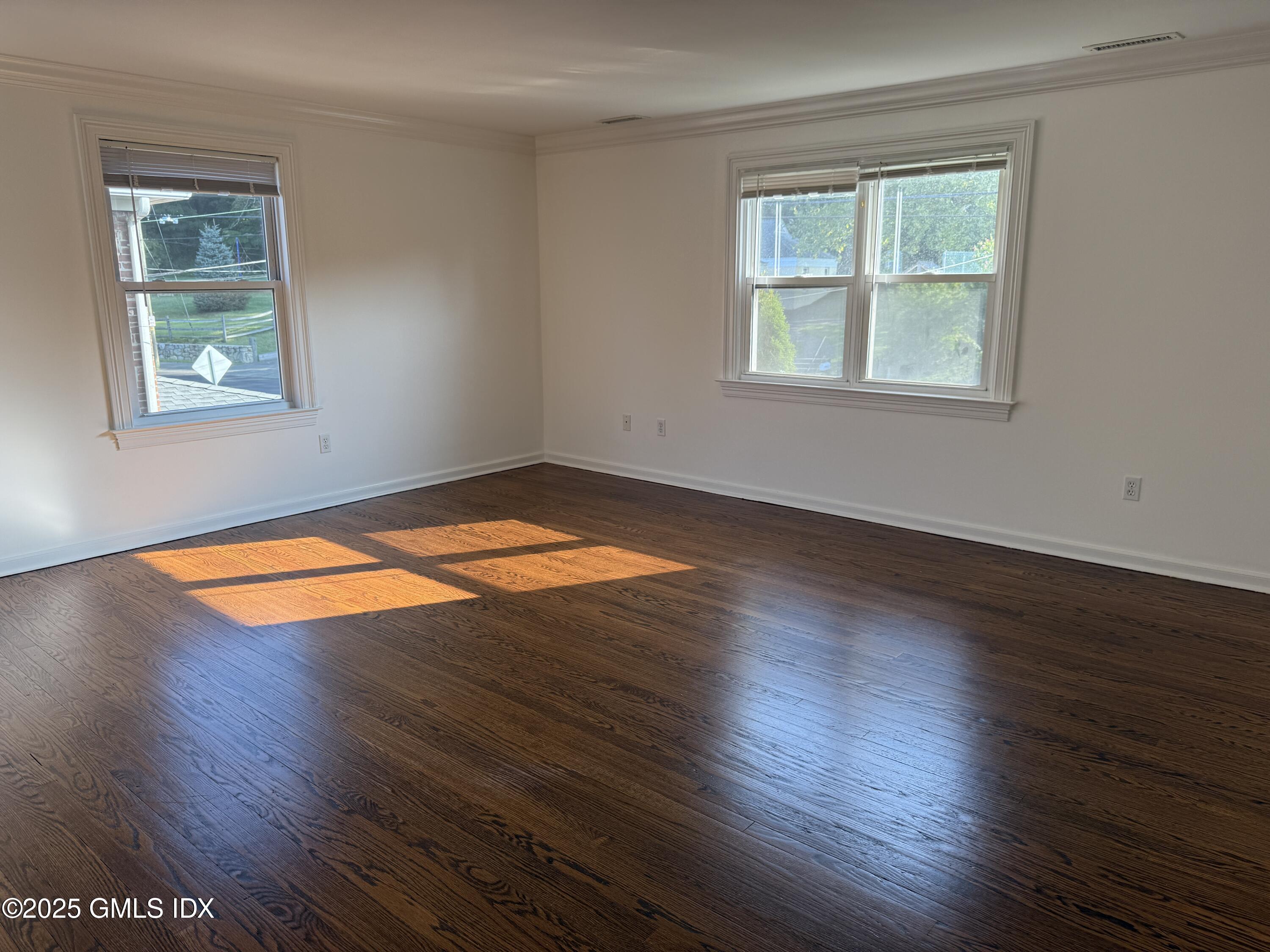 122 Pemberwick Road, Unit 2 Greenwich, CT 06831 - Photo 14 of 17 an empty room with wooden floor and windows