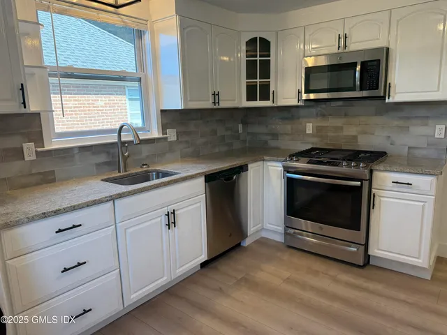 a kitchen with white cabinets stainless steel appliances and sink