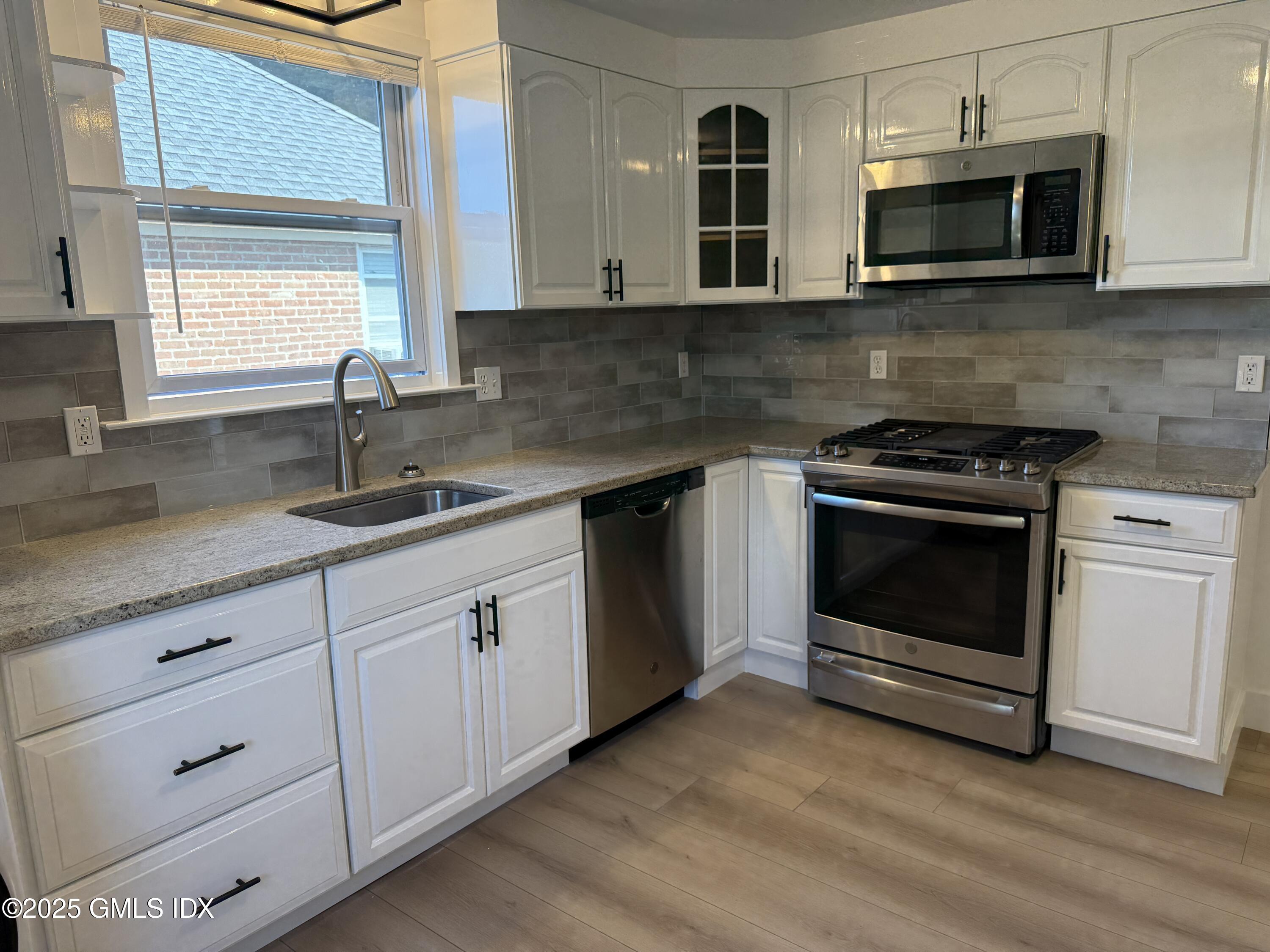 122 Pemberwick Road, Unit 2 Greenwich, CT 06831 - Photo 4 of 17 a kitchen with white cabinets stainless steel appliances and sink