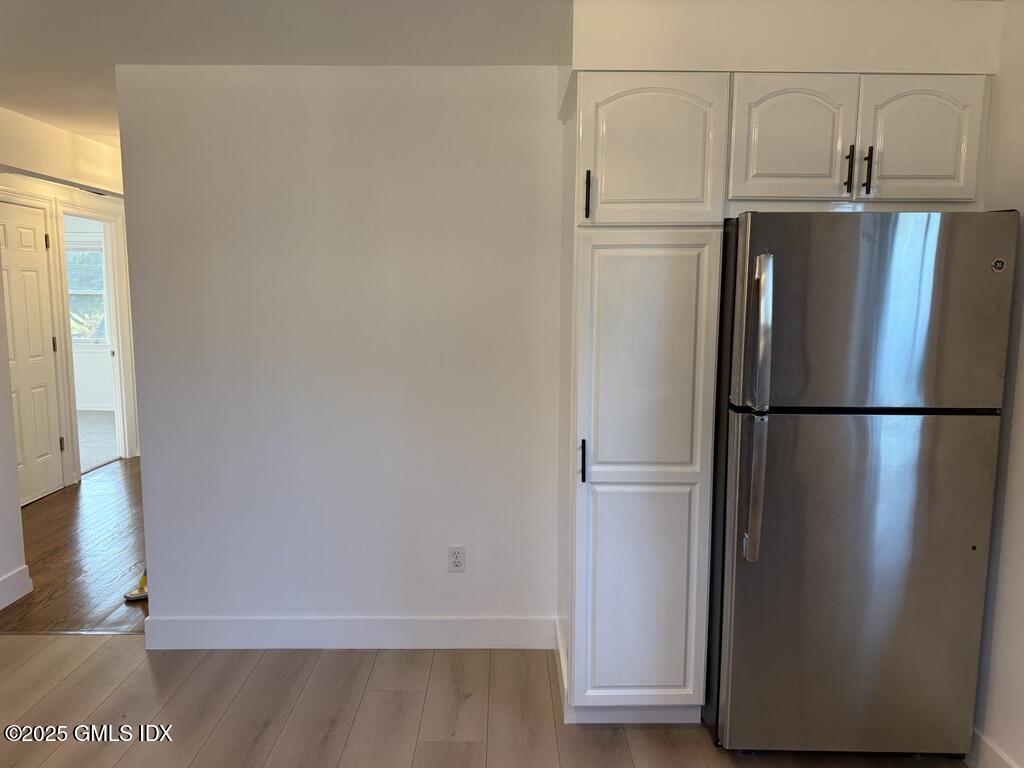 122 Pemberwick Road, Unit 2 Greenwich, CT 06831 - Photo 5 of 17 a view of a refrigerator in kitchen and wooden floor