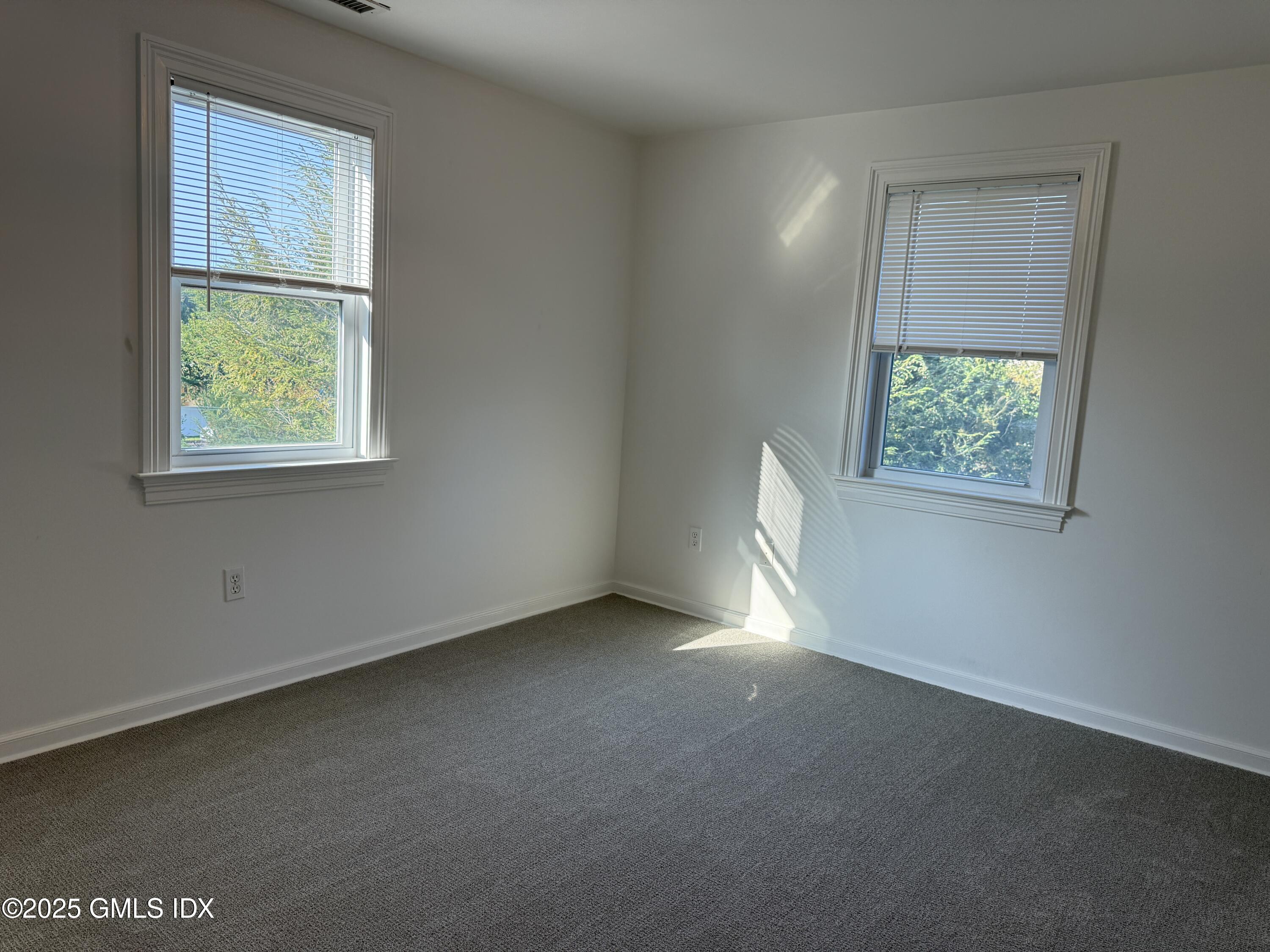 122 Pemberwick Road, Unit 2 Greenwich, CT 06831 - Photo 7 of 17 an empty room with windows