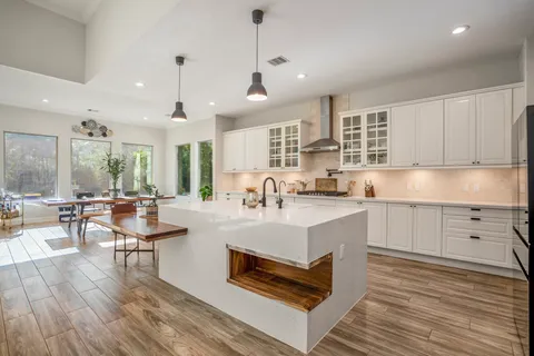 a large white kitchen with lots of counter space a sink and appliances