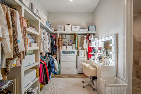 a view of walk in closet with clothes and shoes