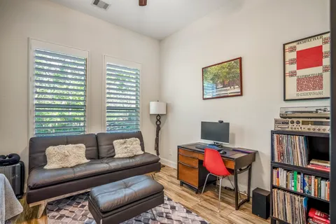 a living room with furniture a bookshelf and a window