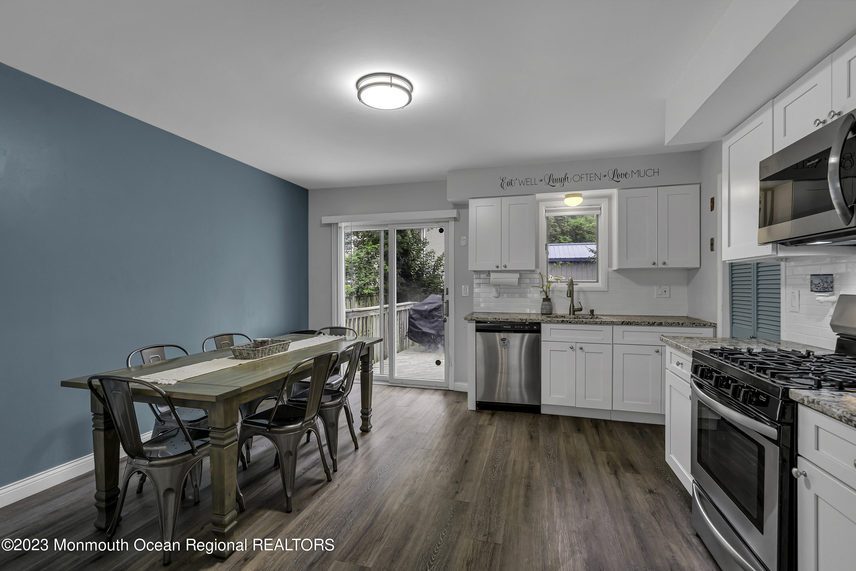 50 Central Avenue Waretown, NJ 08758 - Photo 14 of 35 a kitchen with stainless steel appliances kitchen island hardwood floor sink stove dining table and chairs