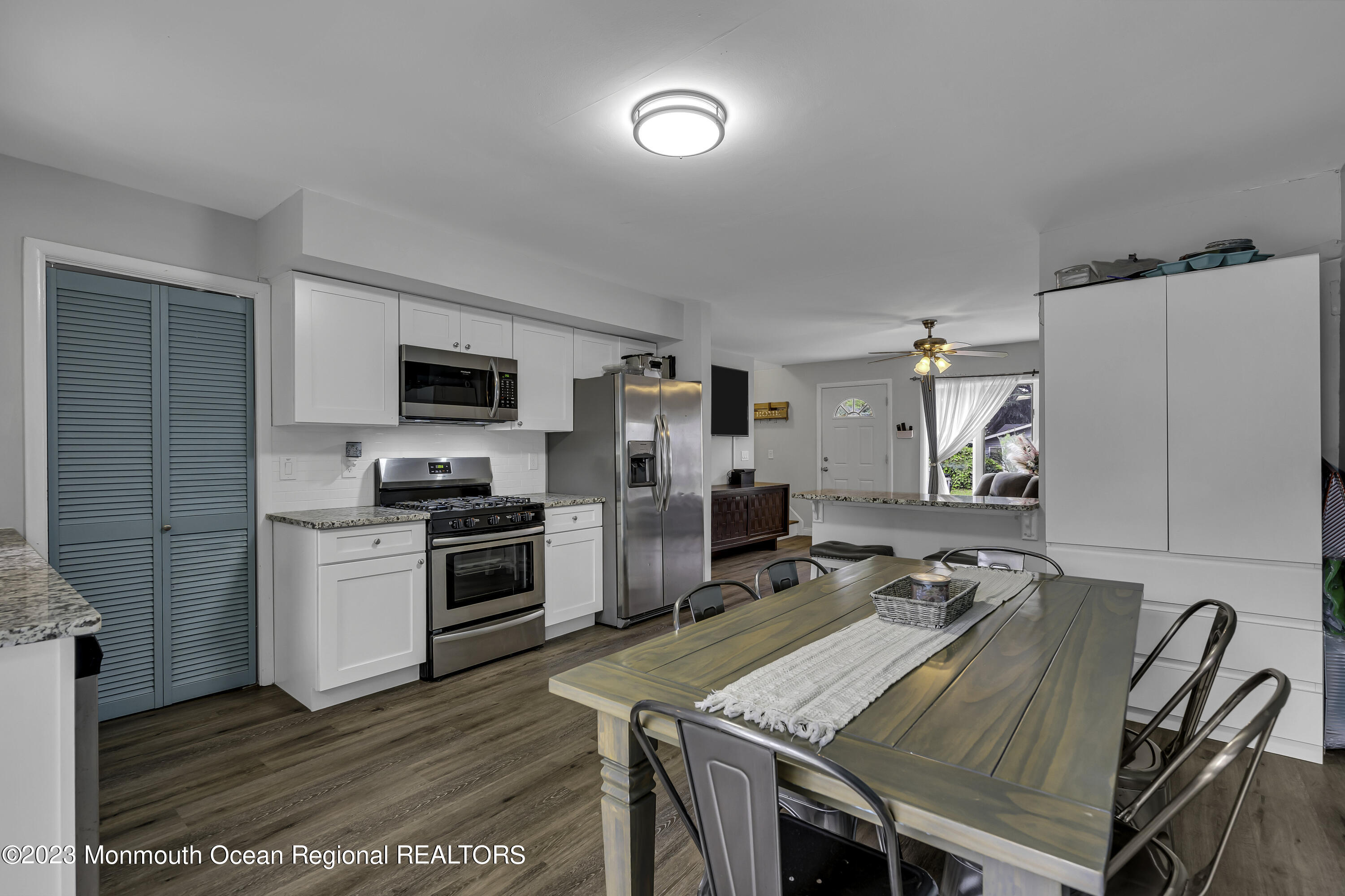 50 Central Avenue Waretown, NJ 08758 - Photo 16 of 35 a open kitchen with stainless steel appliances granite countertop a stove top oven a refrigerator a dining table and chairs with wooden floor
