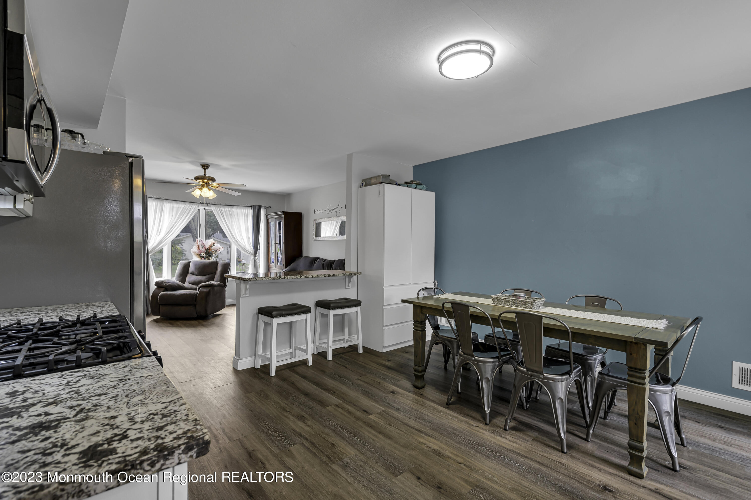 50 Central Avenue Waretown, NJ 08758 - Photo 17 of 35 a kitchen with stainless steel appliances granite countertop a stove top oven a sink dishwasher and a dining table with wooden floor